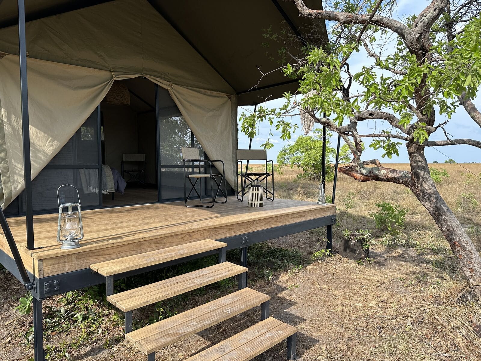 View of a tent with lanterns and outdoor chairs on a deck.  